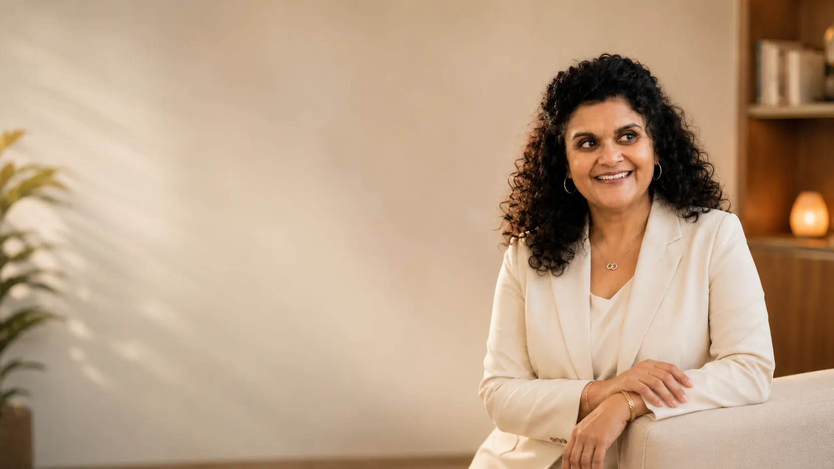 Sandhya Maheshwari seated in warm candlelight, smiling toward the camera